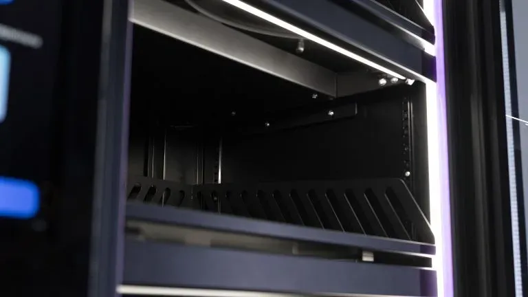 Пустая полка с перфорированной кромкой внутри шкафа, сверху светодиодная подсветка