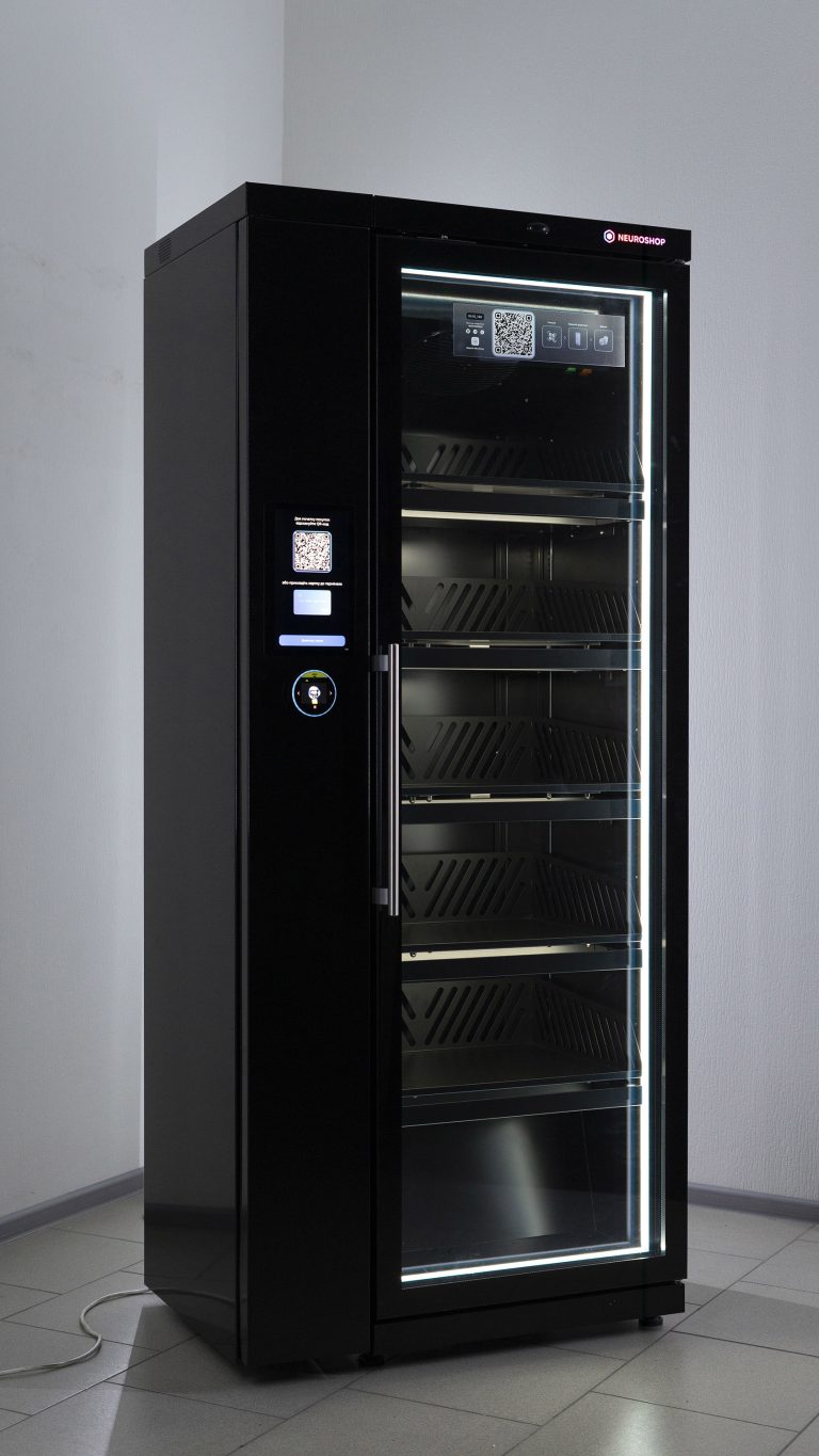 Black cabinet with a glass door, empty lit shelves inside, a screen with a QR code on the front panel