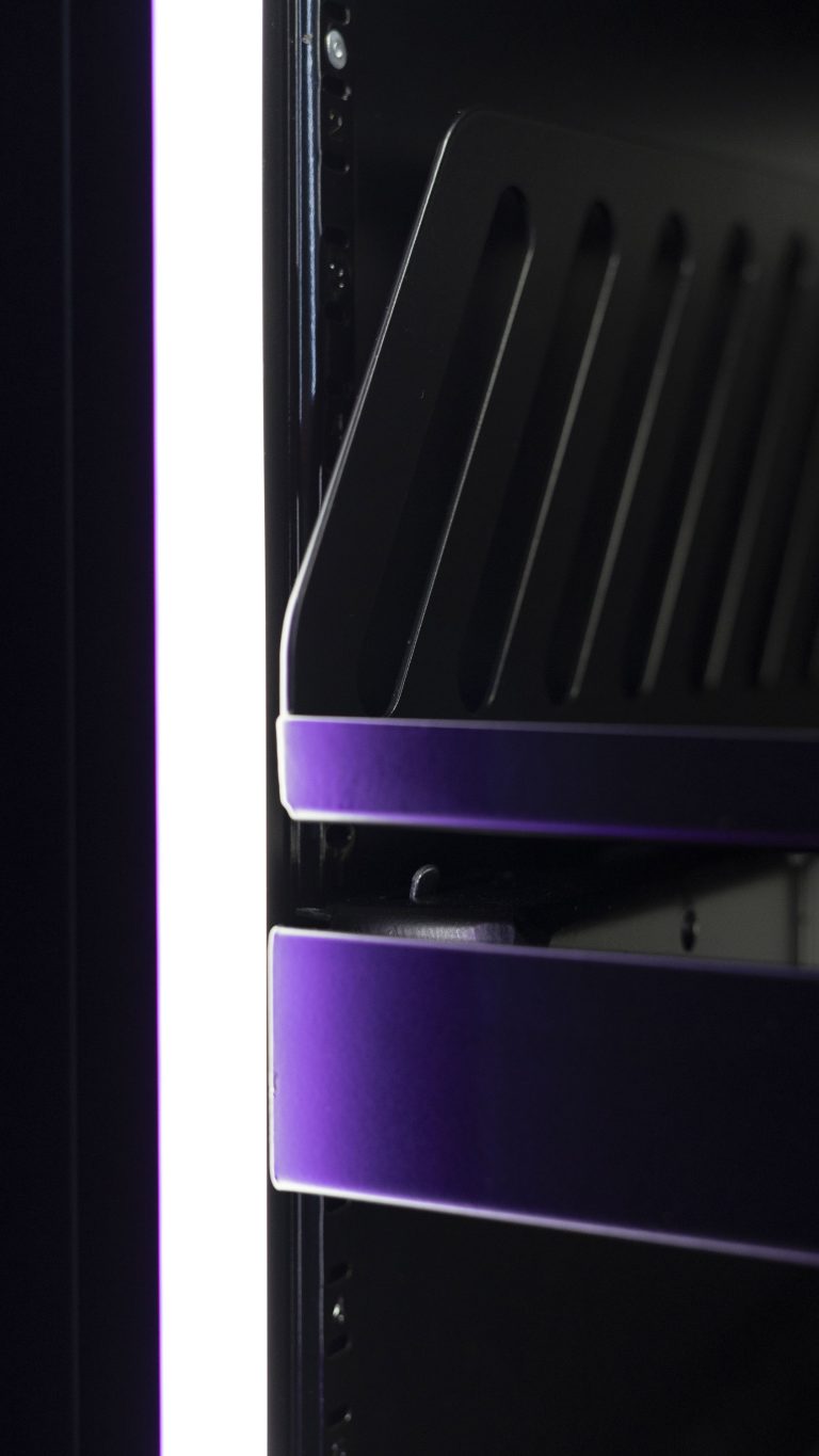 Front edges of two shelves inside a cabinet under dim lighting