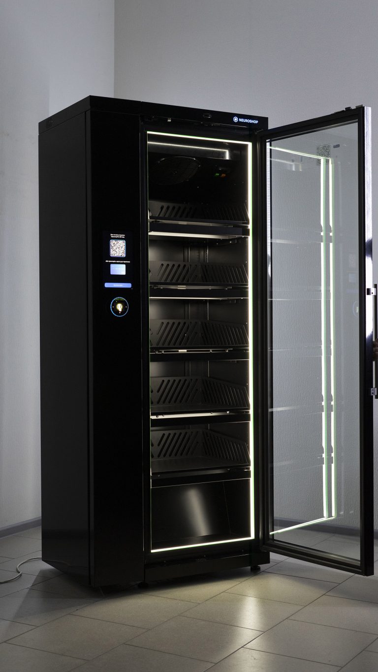 Black cabinet with the glass door open and empty lit shelves