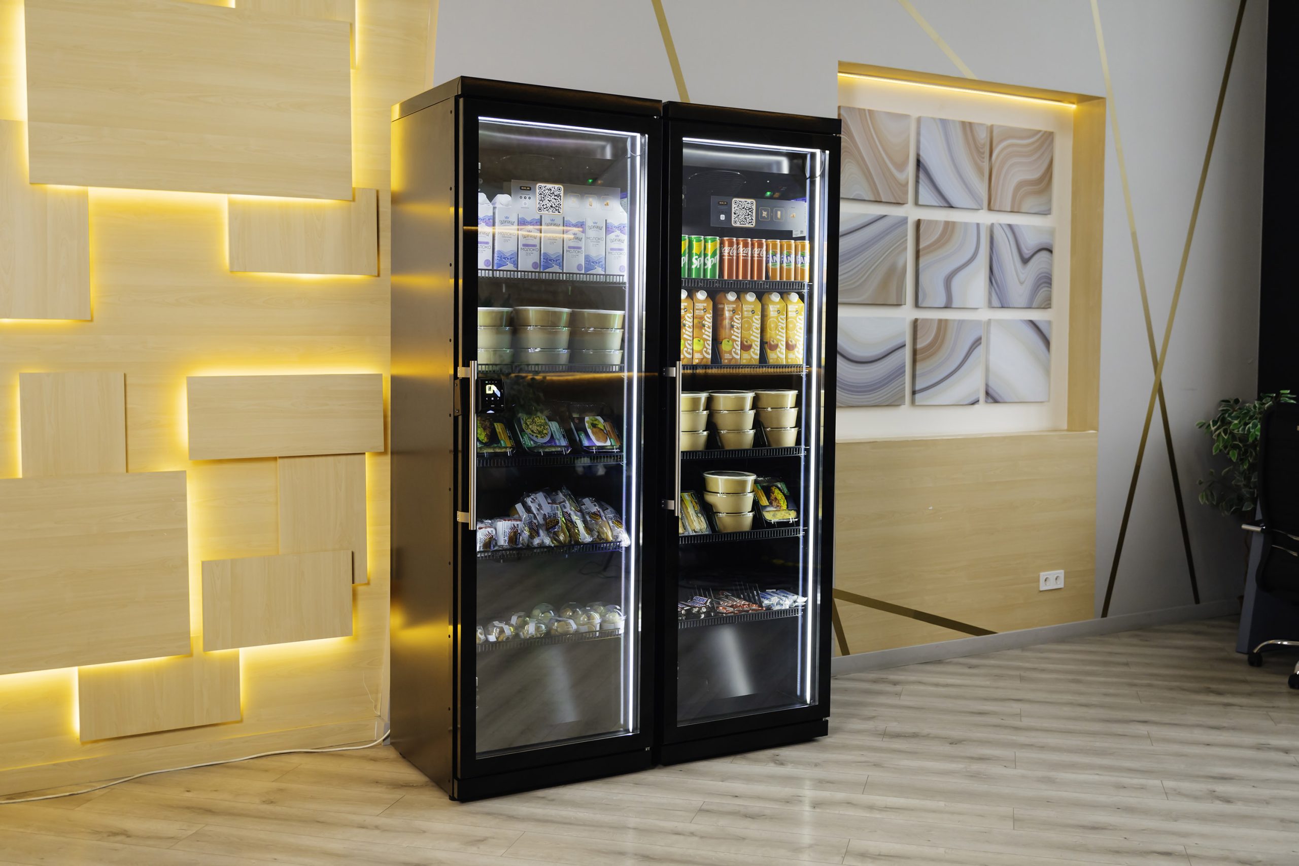 Two black cabinets with glass doors in a room with backlit wood panels