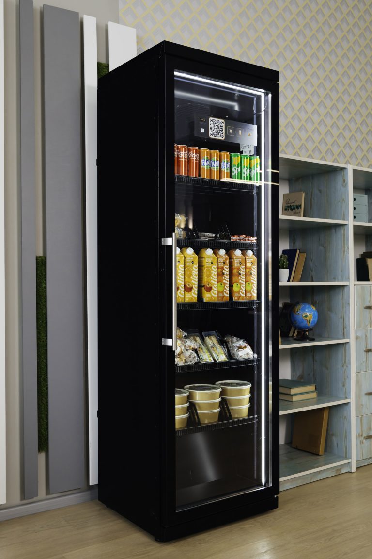 Black cabinet with a glass door next to bookshelves, juice and packaged food on its shelves